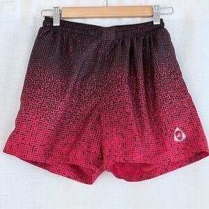 Boy’s red athletic shorts,black geometric pattern,elastic waist,zipped pockets.